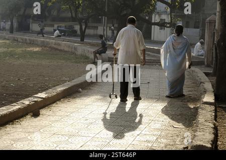 Couple, Old Indian man and woman walking on footpath, Bombay Mumbai, Maharashtra, India, Asia Stock Photo