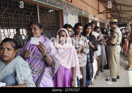 People stand in line to vote at a polling station during general ...