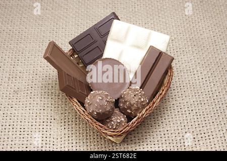 Different varieties of chocolates in heart shaped cane bowl Stock Photo
