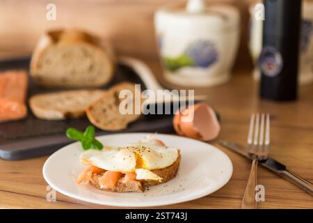 A slice of bread with lightly salted red fish and a cooked egg for breakfast. Stock Photo