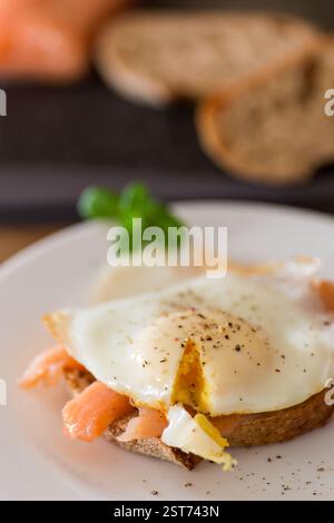 A slice of bread with lightly salted red fish and a cooked egg for breakfast. Stock Photo