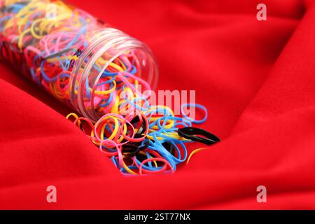 Many elastic bands come out of tubular container Stock Photo