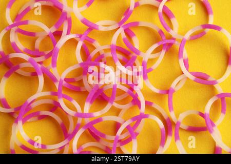 Elastic bands with pink and white combination on yellow background Stock Photo