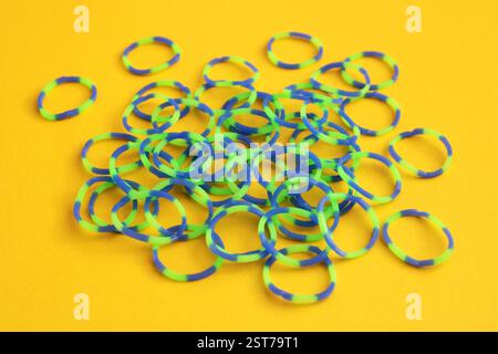 Many elastic bands with green and blue combination on yellow background Stock Photo