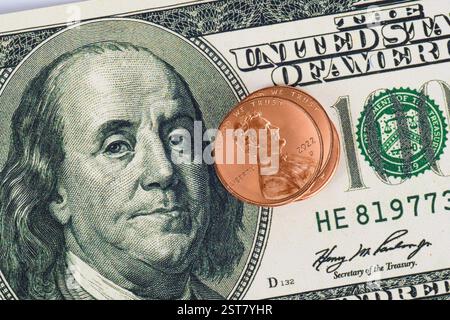 Horizontal shot of three Lincoln pennies with Ben Franklin Hundred Dollar Bill. Stock Photo
