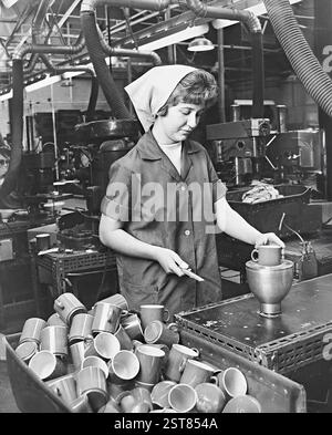 Woman making plastic cups at British Industrial Plastics in Oldbury, West Midlands. 1966 Stock Photo