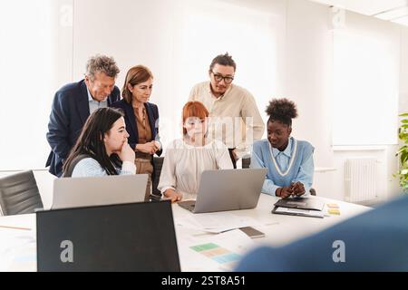 Diverse startup team discussing an innovative business strategy in a modern office. Concept of entrepreneurship, tech development, and creative collab Stock Photo