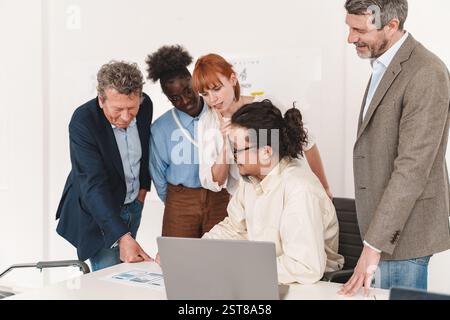 Diverse business team analyzing a mobile app mockup during a creative office meeting. Concept of app development, UX design, and collaborative teamwor Stock Photo