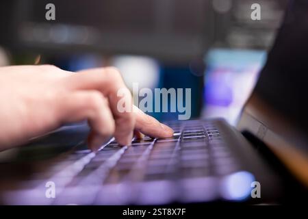 Programmer typing on keyboard, designing and developing software programs, extreme close up shot. Remote IT employee implementing and maintaining company systems on computer Stock Photo