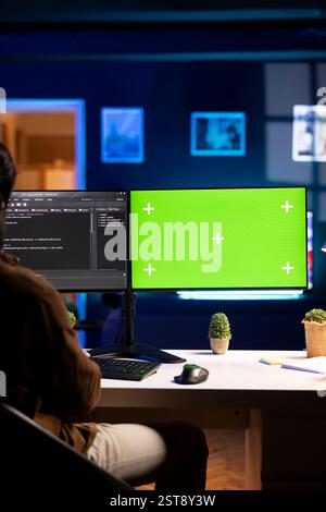 Programmer using green screen computer to secure company servers from virus attacks. IT remote employee writing code, building firewalls protecting data using mockup PC monitor Stock Photo