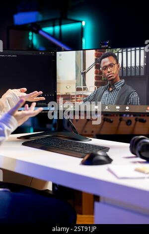 IT professional working from home in videocall with coworker, testing and deploying programs and systems. Admin checking code with colleague in teleconference, sitting at desk chair in apartment Stock Photo