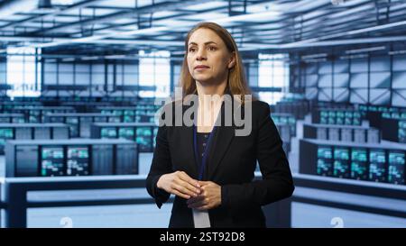 System administrator in high tech data center looking at hologram visualization. Computer scientist working on securing server terminals using AR tech, preventing hacker attacks, camera A Stock Photo