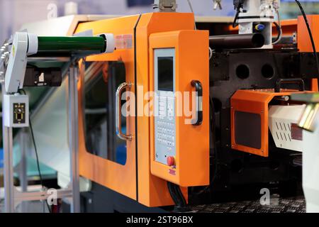 Plastic injection molding machine and conveyor belt. Selective focus. Stock Photo
