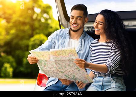Loving middle-eastern couple watching map while having break Stock Photo