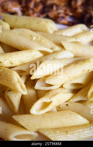 Delicious cooked penne pasta served with spices and herbs Stock Photo