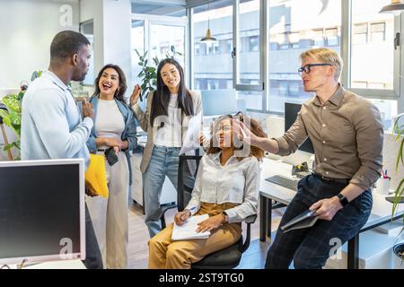 Multi ethnic business team collaborating and sharing ideas in a modern coworking office space, fostering teamwork and innovation Stock Photo