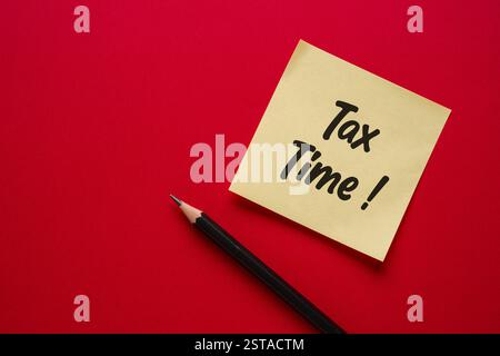 Top view of yellow sticky note with Tax Time written on it Stock Photo