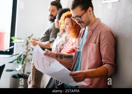 Happy businesspeople laughing while collaborating on a new project in an office. Business startup. Stock Photo