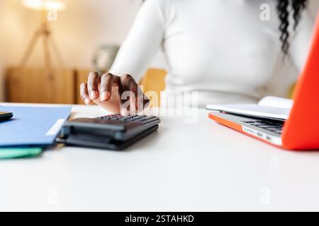 Accountant using calculator working at home office calculating expenses Stock Photo