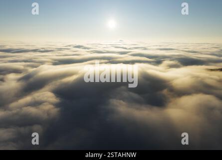 Beautiful sunset cloudy sky from aerial view. Airplane view above clouds Stock Photo