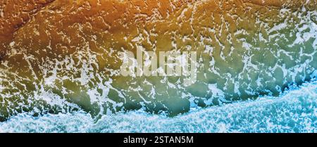Ocean surf. Waves roll onto the shore. View from above. Nature abstract background. Horizontal banner Stock Photo