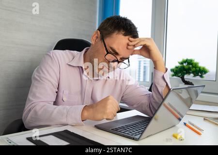 Businessman office working holding sore head pain from desk working and sitting all day using laptop computer suffering headache sick worker overworki Stock Photo