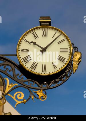 Clock at St Martin Le Grand, Coney Street in York seen against a blue sky. Stock Photo