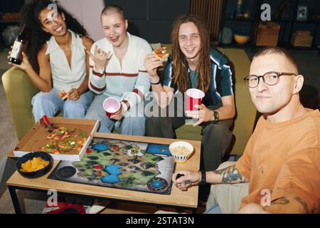Enjoying Board Game Night with Friends Around Table Stock Photo