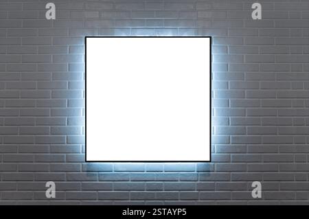 frame 1:1 hanging on a brick wall illuminated wit LED light Stock Photo