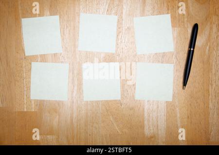 Pen and Post It Notes Pad Against a Wood Background Stock Photo