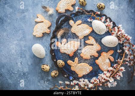 Homemade almond bunny cookies for Easter with Easter eggs in blue tone Stock Photo