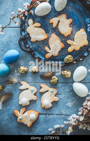 Homemade almond bunny cookies for Easter with Easter eggs in blue tone Stock Photo