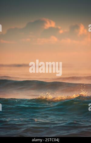 Golden Sunset Reflecting on Ocean Waves Under Vibrant Sky Stock Photo