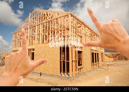 Female Hands Framing Home Frame on Construction Si Stock Photo