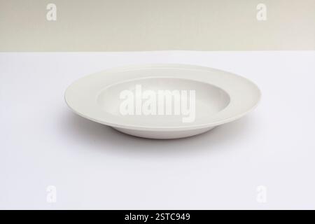 Minimalistic photo of an empty white plate on a neutral background, showcasing simplicity and elegance. Stock Photo