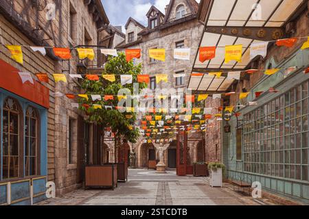Red, white and yellow banners across a traditional european style alleyway taken in Da Nang Vietnam Stock Photo