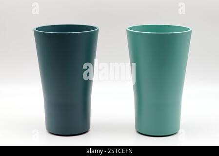 Two modern teal and mint green plastic cups isolated on white background Stock Photo
