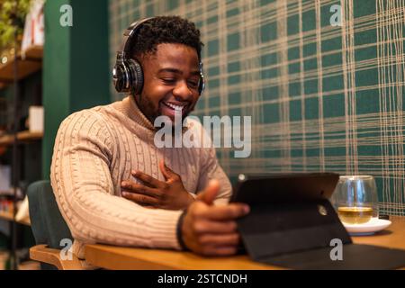 Freelancer using digital tablet to communicate online. He is sitting in bar and having video call. Stock Photo
