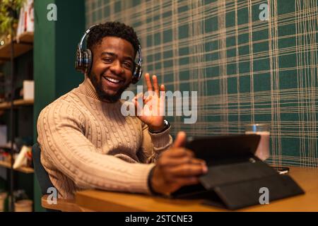 Freelancer using digital tablet to communicate online. He is sitting in bar and having video call. Stock Photo