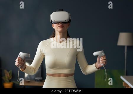 Woman Engaging in Virtual Reality Experience with Controllers Stock Photo