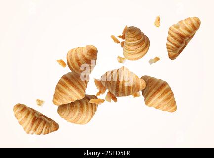 Delicious croissants and crumbs in air on white background. Puff pastry Stock Photo