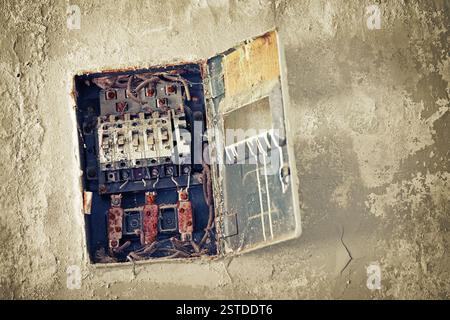Old bad rusty switch box on wall Stock Photo