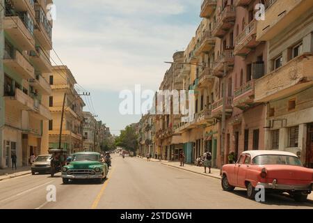 Vanishing perspective of city street view of Havana City Cuba. Light traffic, vintage cars on road on sunny day. Stock Photo