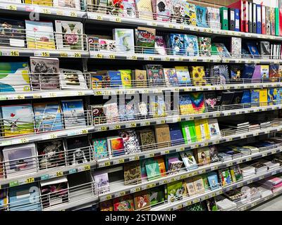 Lviv, Ukraine - February 16, 2025: Variety of notebooks and stationery items displayed on a shelf in a store. Stock Photo