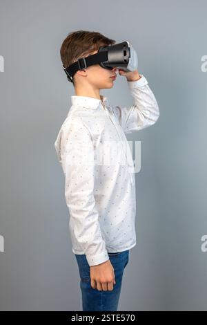 A young individual experiences virtual reality, wearing a VR headset, immersed in a digital environment Stock Photo