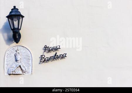 Wall Shrine of Mary with Decorative Lamp on a White Plaster Background Stock Photo