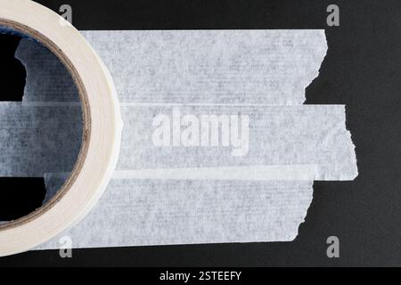Roll of adhesive tape on black background. Copy space for text Stock Photo