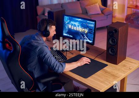 Focused on the playing. Man streaming FPS shooter game at home. Stock Photo