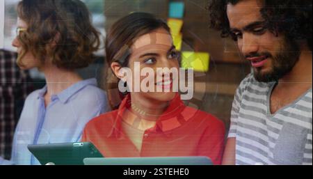 Digital interface image over diverse colleagues collaborating with tablets Stock Photo