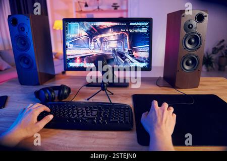 Hands on the mouse and keyboard. Online streamer playing FPS shooter game at home. Stock Photo